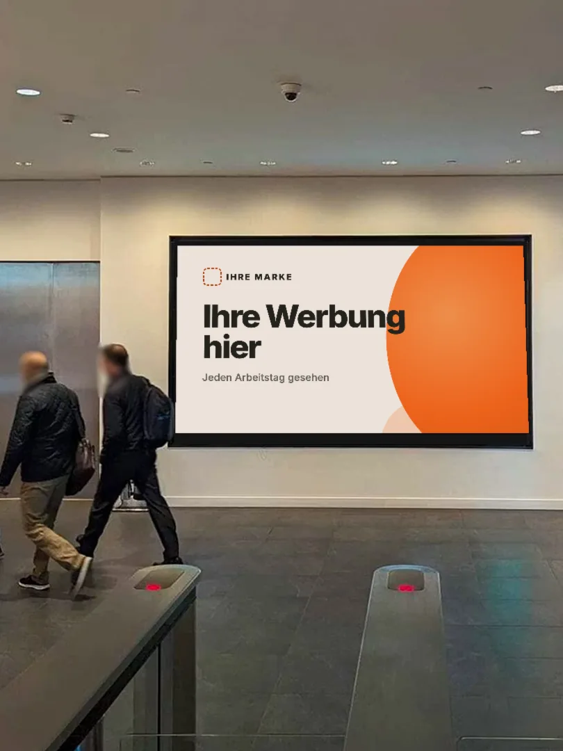 Beispielfoto: zwei Personen gehen in einer Bürolobby an einem großen Bildschirm mit einer Musteranzeige vorbei